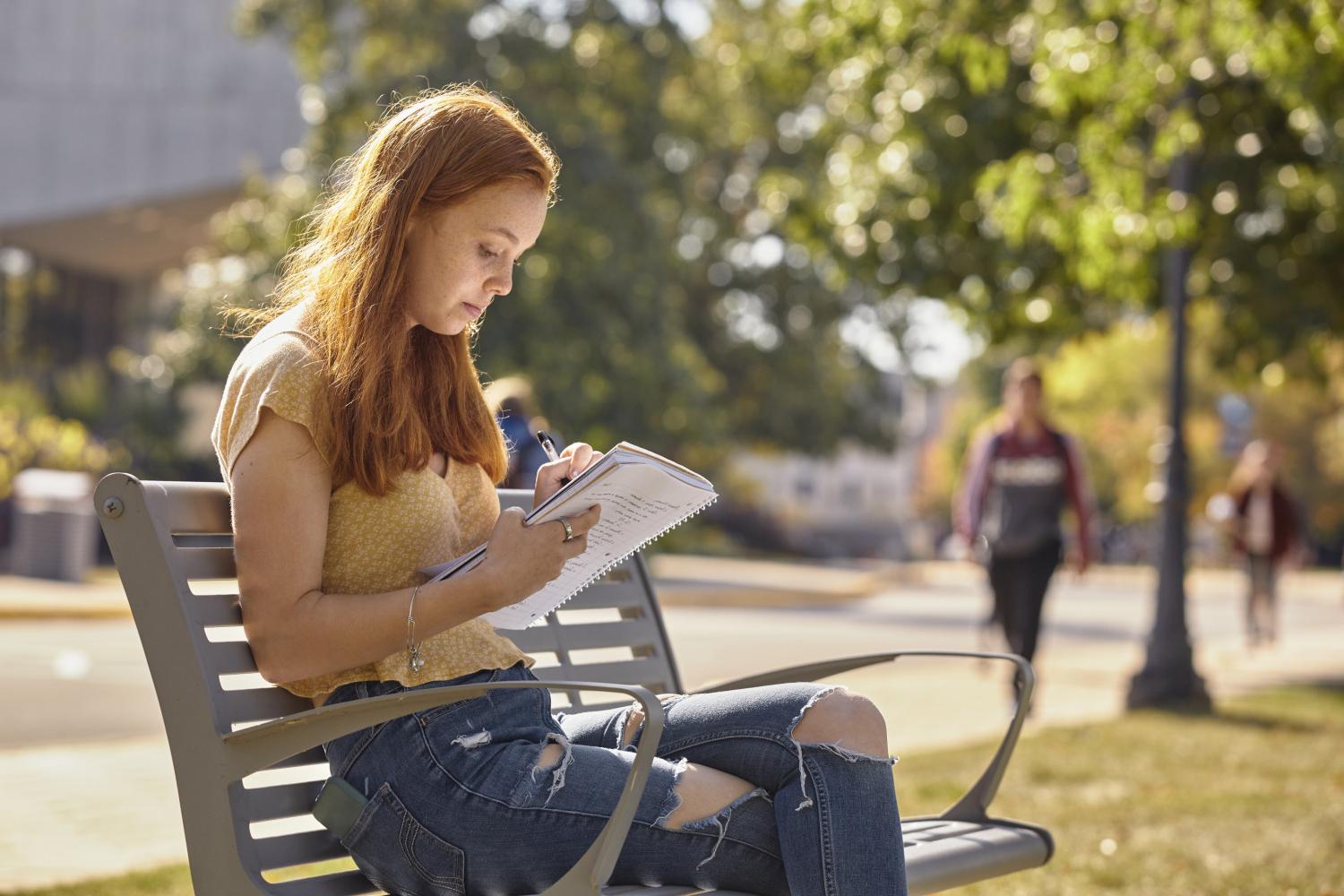一位<a href='http://rb.tjxxsls.com/'>全球十大赌钱排行app</a>学院的学生在校园里的长椅上读书.